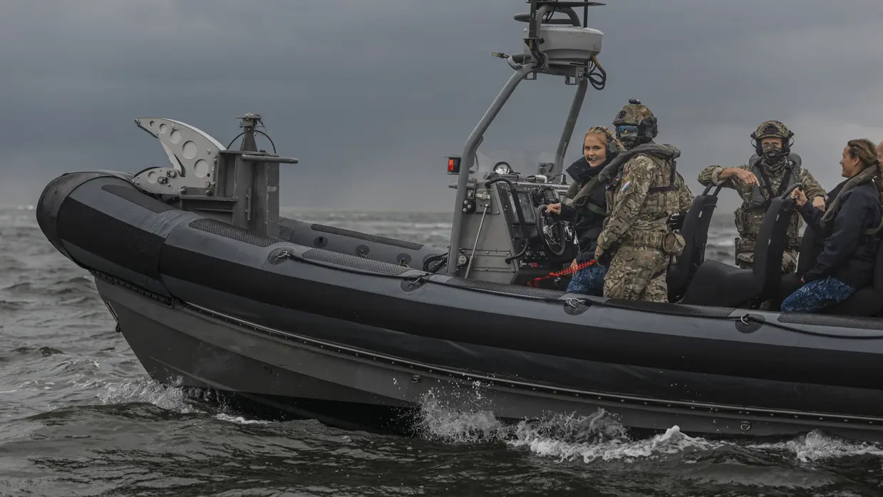 Het snelle vaartuig de FRISC scheert over het wateroppervlak. Aan boord meerdere miilitairen, inclusief een lachende prinses