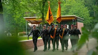 Adjudant Cor Binsma loopt met het vaandel   De vaandels tijdens de herdenking 