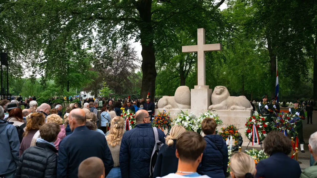 Publiek voor het Nationaal Monument op de Grebbeberg, waarvoor kransen staan en liggen. 