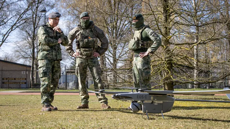 De CDS kijkt met andere militairen naar een drone. 