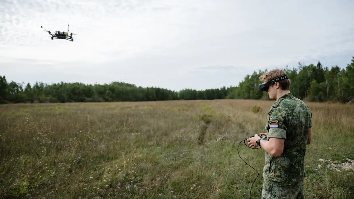 Militair met speciale bril en afstandsbediening bestuurt drone