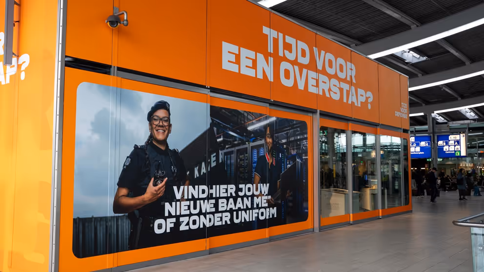 Oranje pop-up store met een foto van een vrouwelijke militair en de tekst: Tijd voor een overstap? 