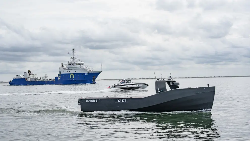 Een bemand en onbemand schip op open water.
