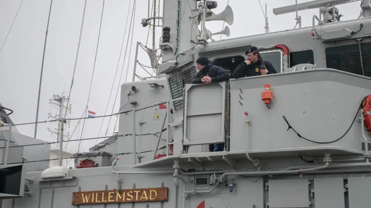 Zij-aanzicht marineschip met naambord Zr.Ms. Willemstad.