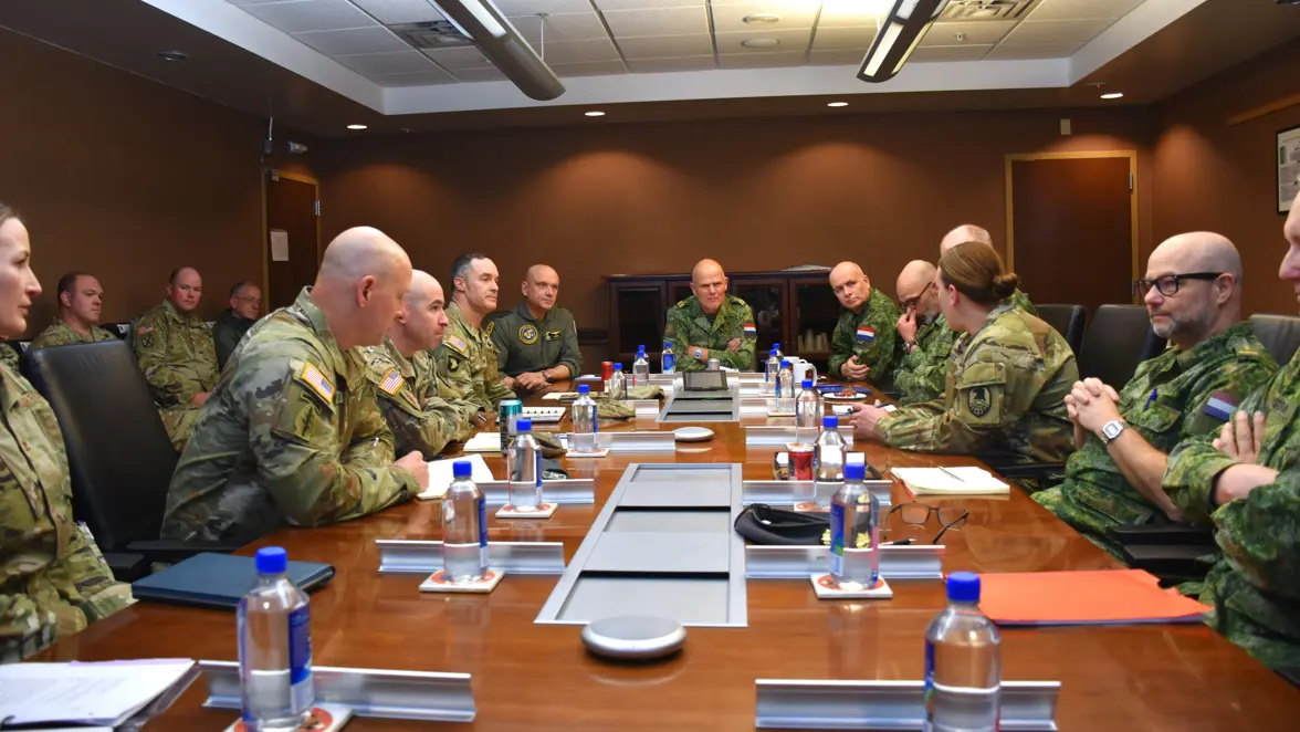 Militairen met elkaar in gesprek aan een tafel.
