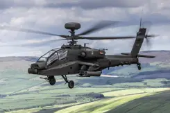 Een lviegende Apache gevechtshelikopter met heuvels op de achtergrond.