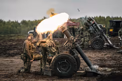 Vuurbal bij afschieten mortier. Militairen staan erbij.