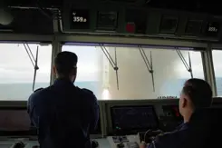2 mariniers zien door het raam vanaf de brug van het schip de afgevuurde raket.