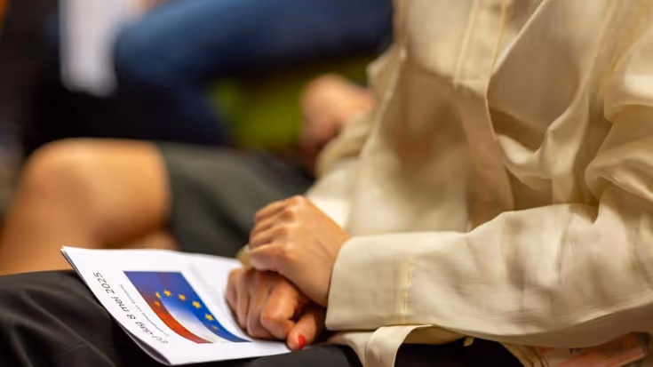 Iemand heeft een pamflet op schoot.