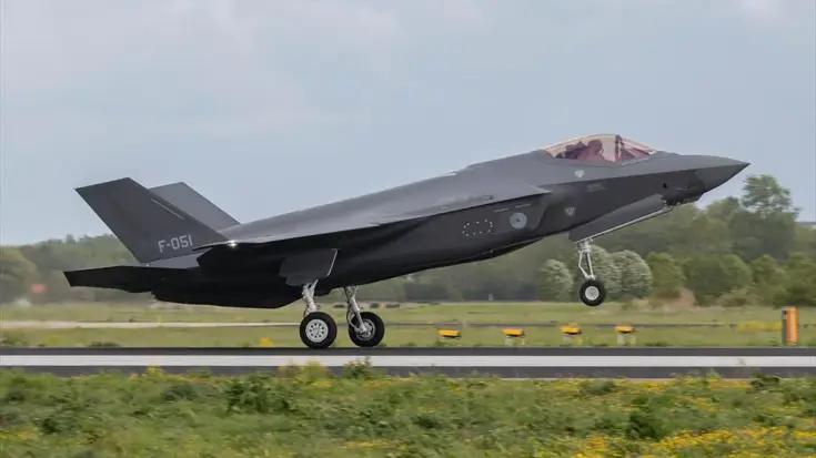Een grijs F-35-jachtgvliegtuig stijgt op vanaf een start- en landingsbaan.    