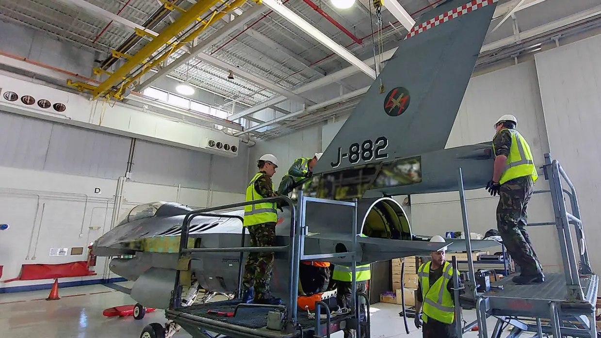Mensen werken aan een militair vliegtuig.