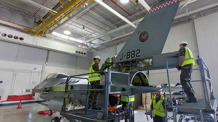 Mensen werken aan een militair vliegtuig.