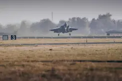 F-35 met neus omhoog vlak boven de grond van landingsbaan.