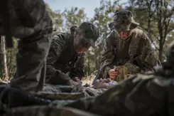 Militairen behandelen gewonde collega tijdens oefening.