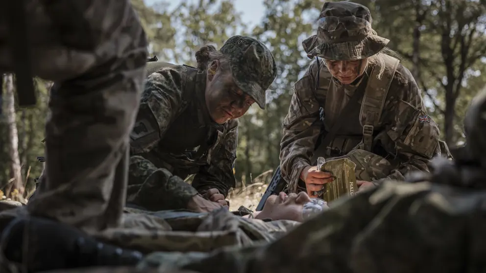 Militairen behandelen gewonde collega tijdens oefening.