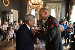 94-jarige KNIL-veteraan krijgt 2 medailles opgespeld.