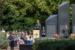 De minister spreekt tijdens de herdenking.