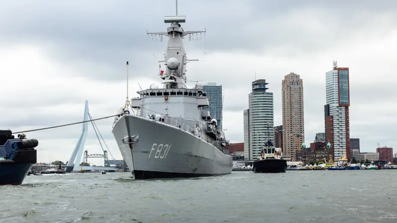 Zr.Ms. Van Amstel die aanmeert met op de achtergrond de Erasmusbrug. 