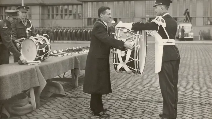 Burgemeester van Apeldoorn Des Tombe overhandigt een van de instrumenten.