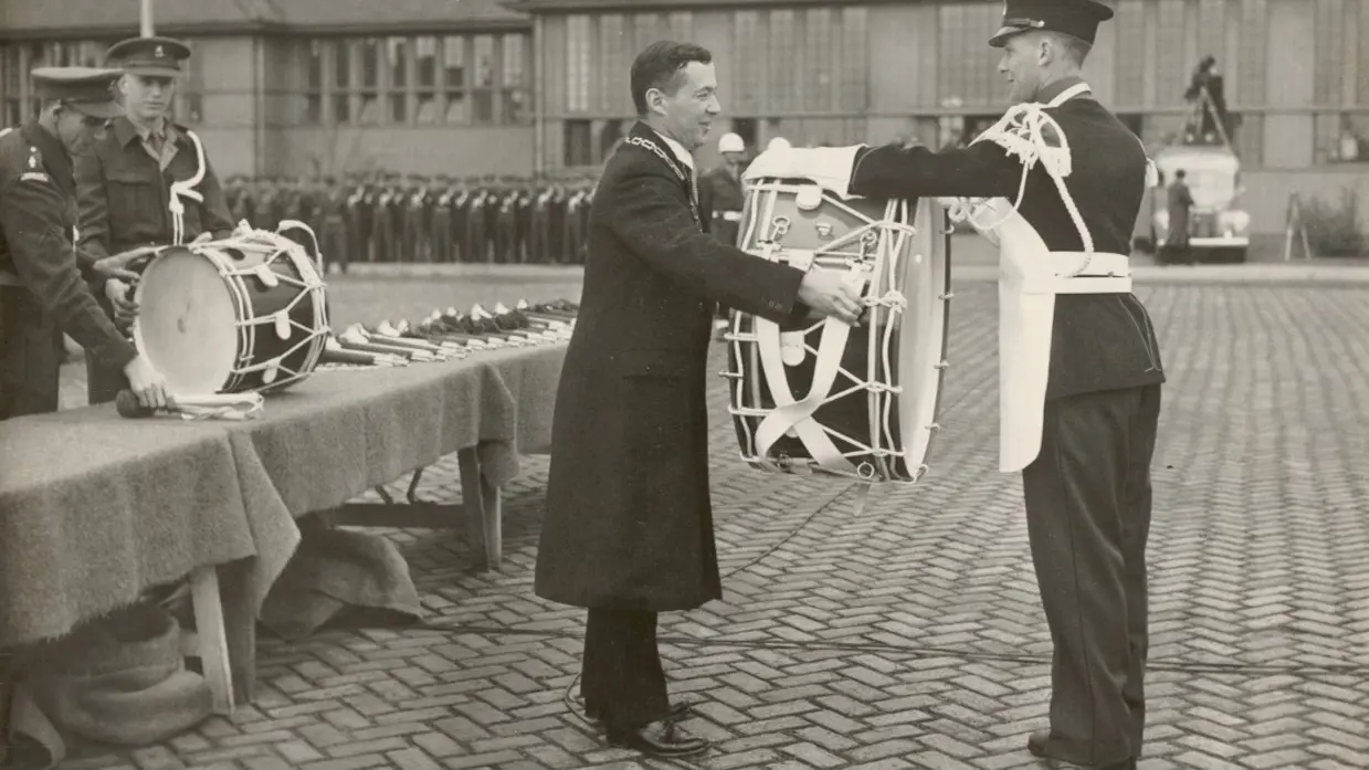 Burgemeester van Apeldoorn Des Tombe overhandigt een van de instrumenten.