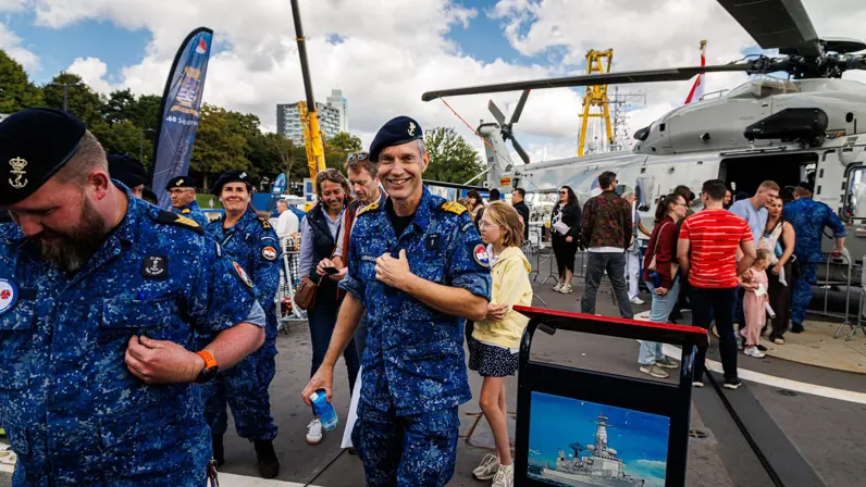 Op de foto een lachende viceadmiraal Harold Liebregs op het helidek van de Van Amstel, met op de achtergrond een tentoongestelde helikopter.  