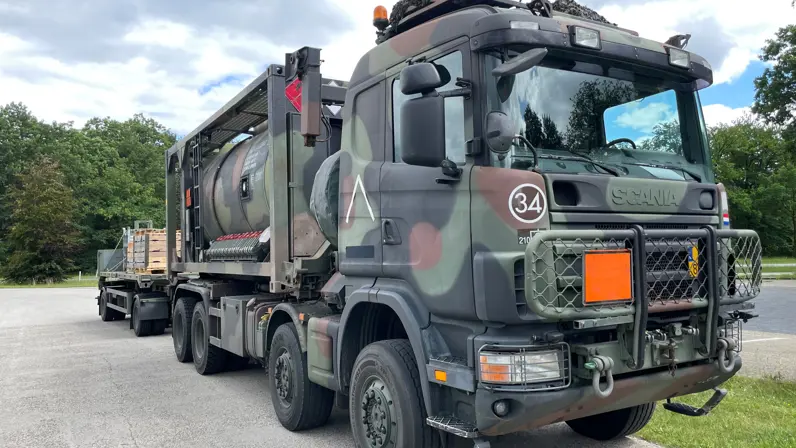 een legervrachtwagen in een groene omgeving.     