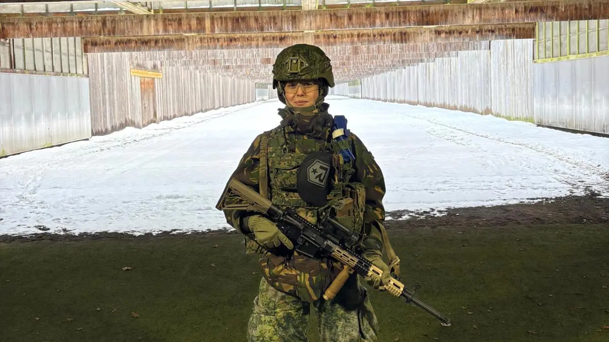 Floor staat in militair tenue met helm en wapen op een schietbaan.