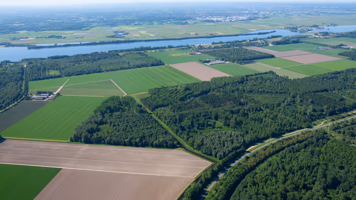 Luchtfoto van landelijk gebied met bos, weilanden en water
