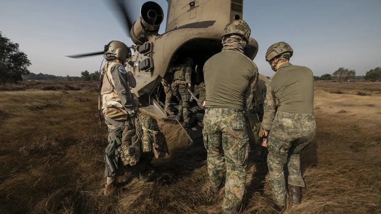 Militairen dragen een oefengewonde in een Chinook-transporthelikopter.