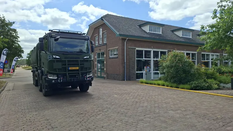 Een militair voertuig rijdt over de WGF Kazerne in Harderijk 