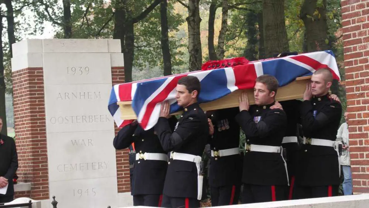 Tijdens een herbegrafenis dragen militairen de kist van een Britse soldaat van het Wiltshire Regiment.