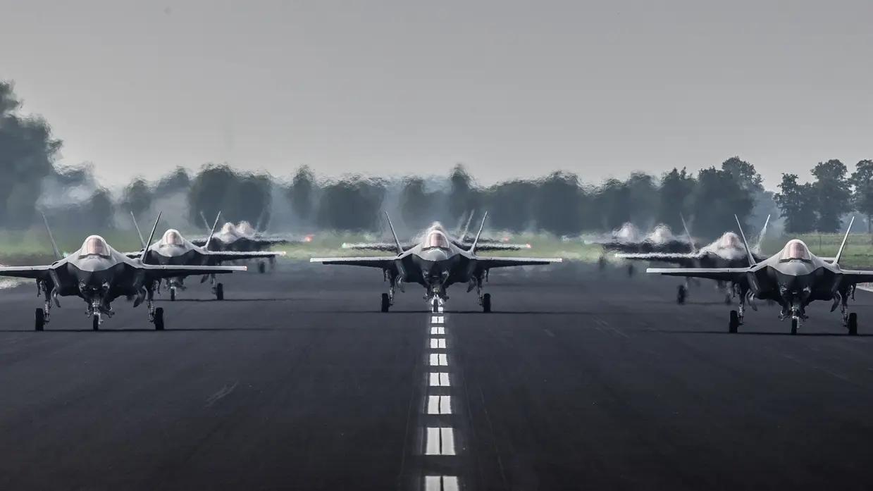 Start- en landingsbaan op een vliegbasis met bewolkte lucht.