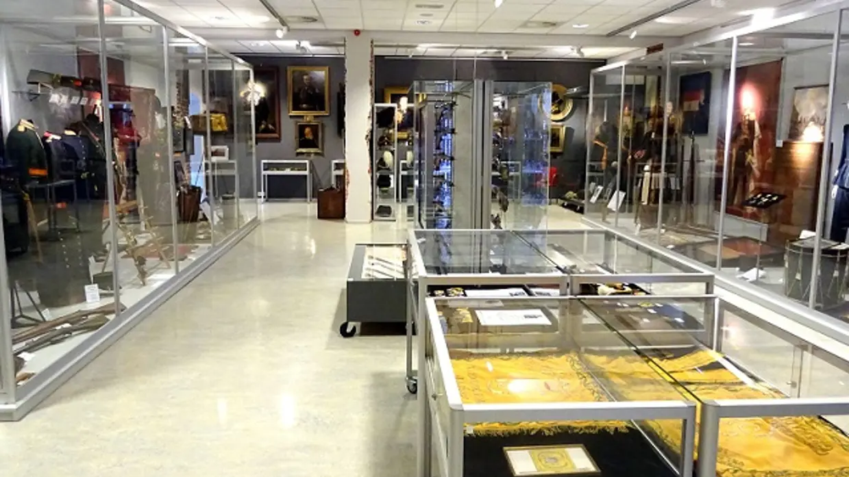 Museum met militairen uniformen en spullen in vitrines.
