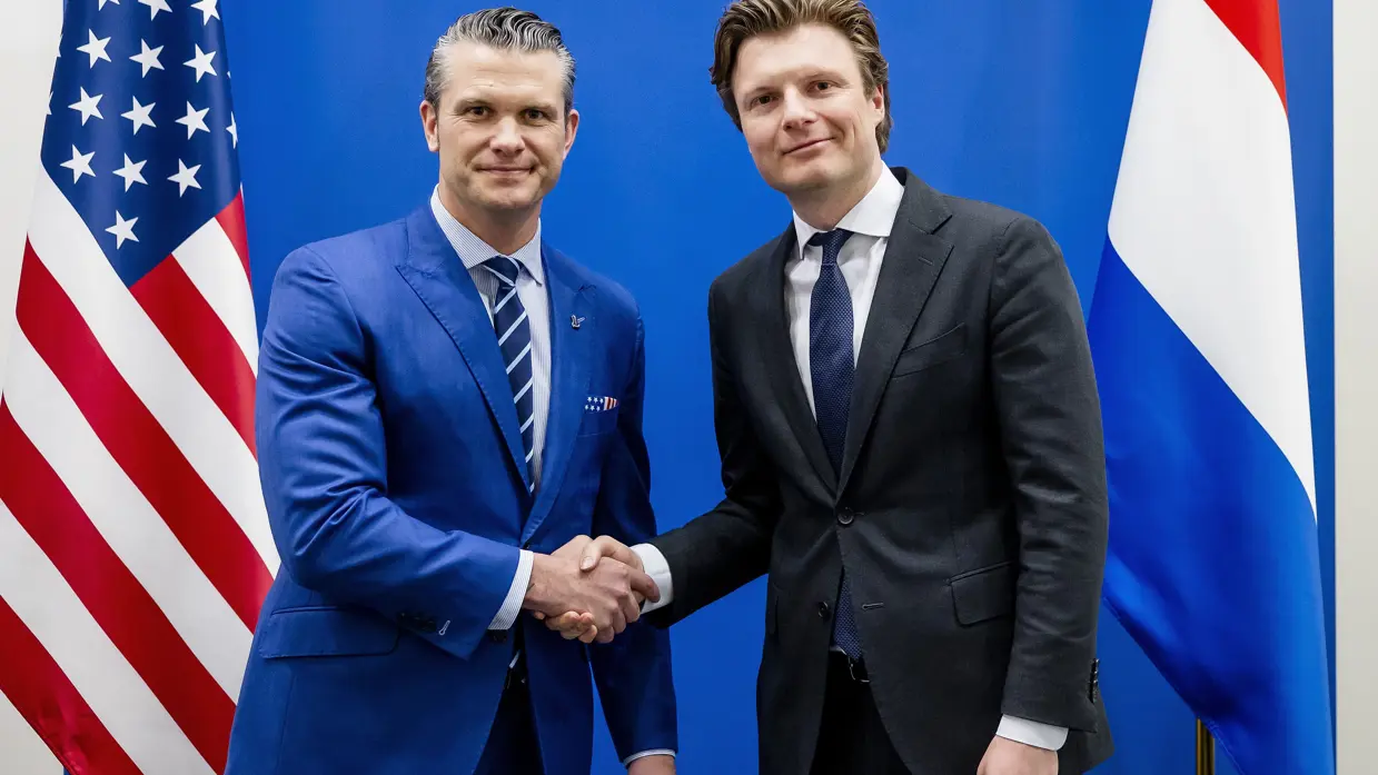 De minister schudt de hand van zijn Amerikaanse collega.