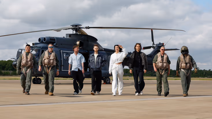 Artiesten en bemanning lopen weg bij helikopter.