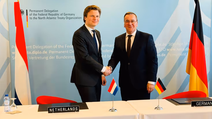 Defensieministers van Nederland en Duitsland schudden elkaar de hand.