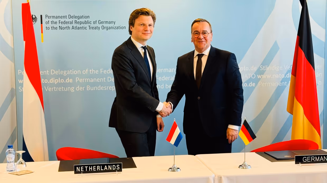 Defensieministers van Nederland en Duitsland schudden elkaar de hand.