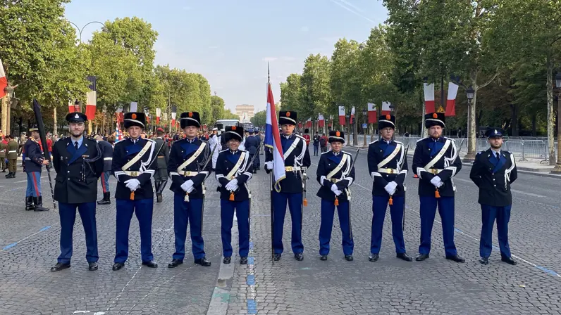 Negen marechaussees, van wie zeven in ceremonieel tenue, staan op een rij.