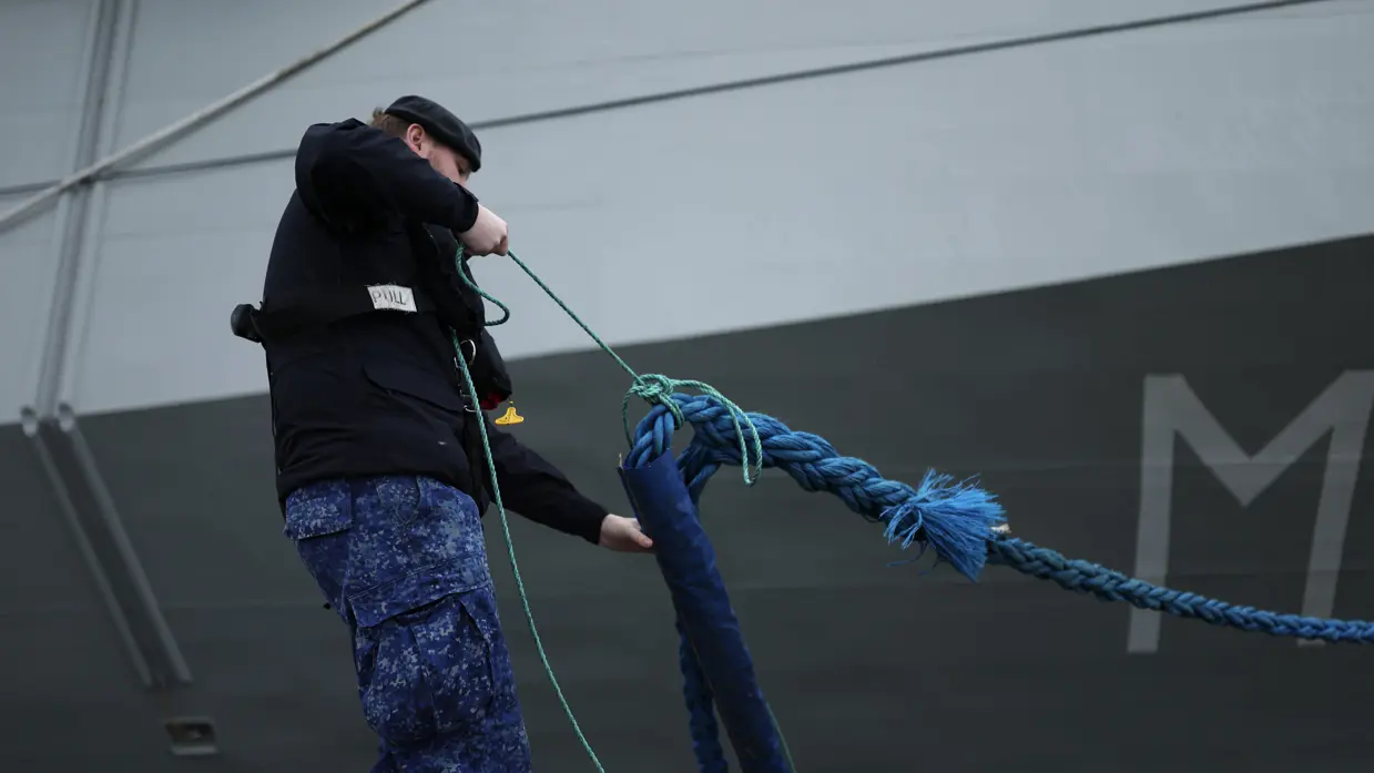 Een militair haalt een touw naar binnen.