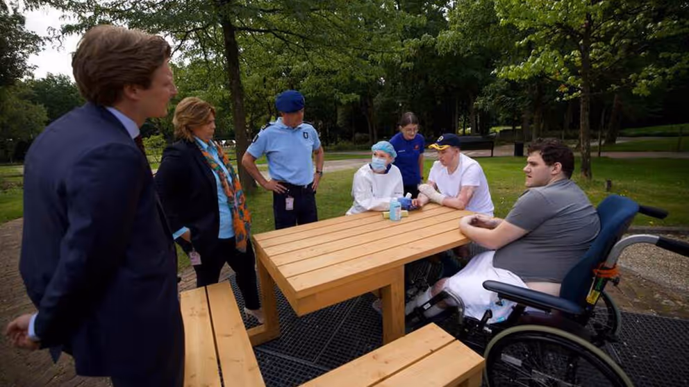 De minister in gesprek met revaliderende militairen.