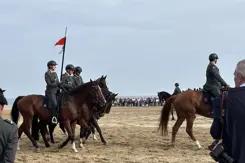 De ruiters met hun paarden op het strand. 