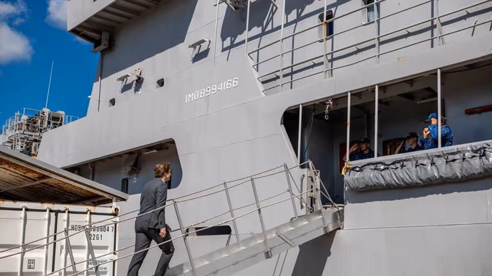 De minister stapt aan boord van een schip.