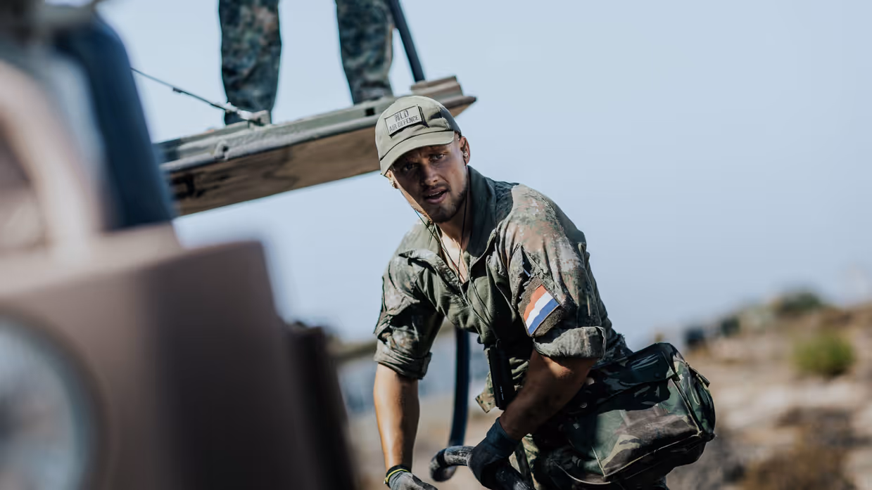 Een militair is bezig met werkzaamheden.