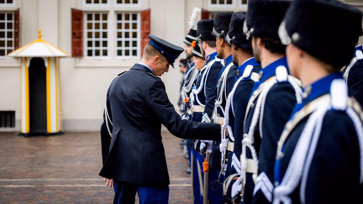 Militairen in ceremonieel ornaat worden geinspecteerd.