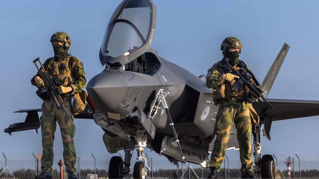 Twee militairen staan op wacht bij een F-35 straaljager.