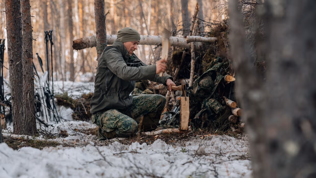 Een militair is hout aan het hakken