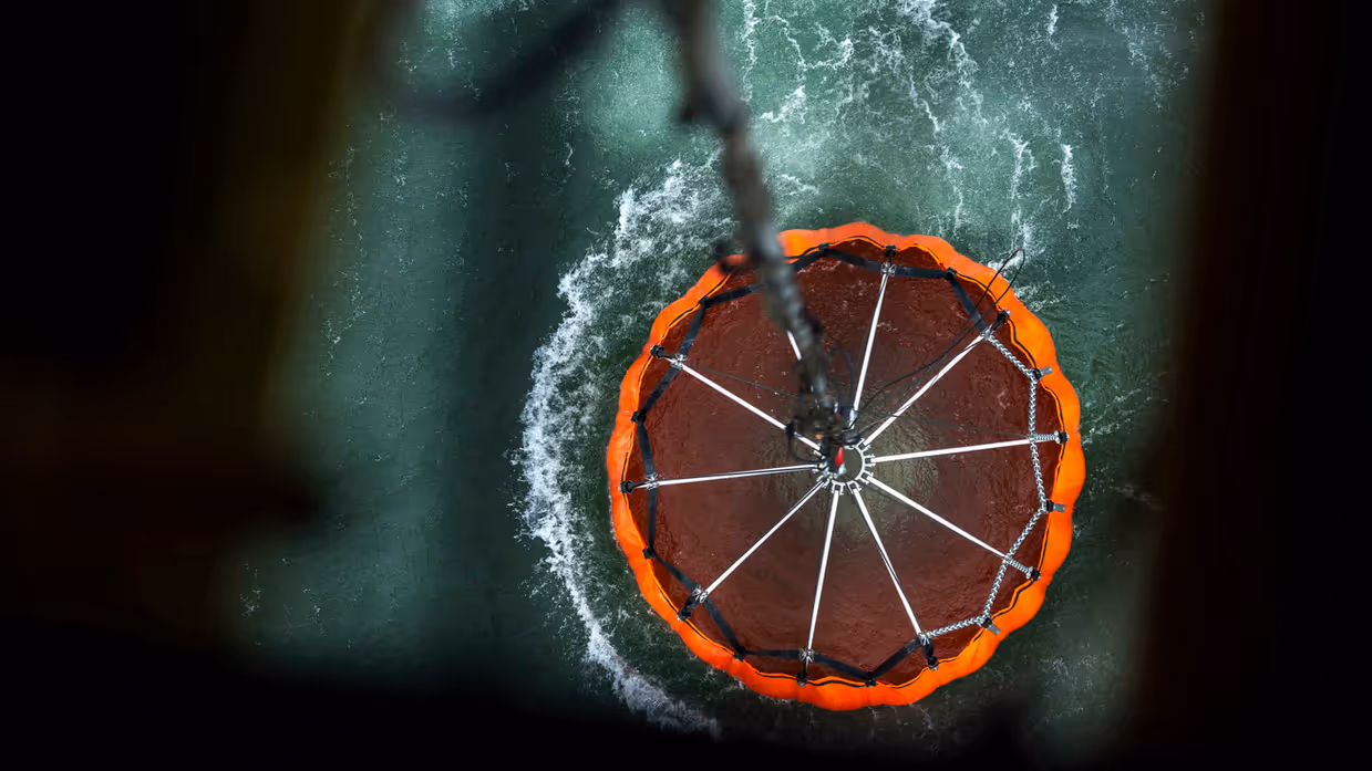 Een zeil bevestigd aan een helikopter schept water uit een rivier