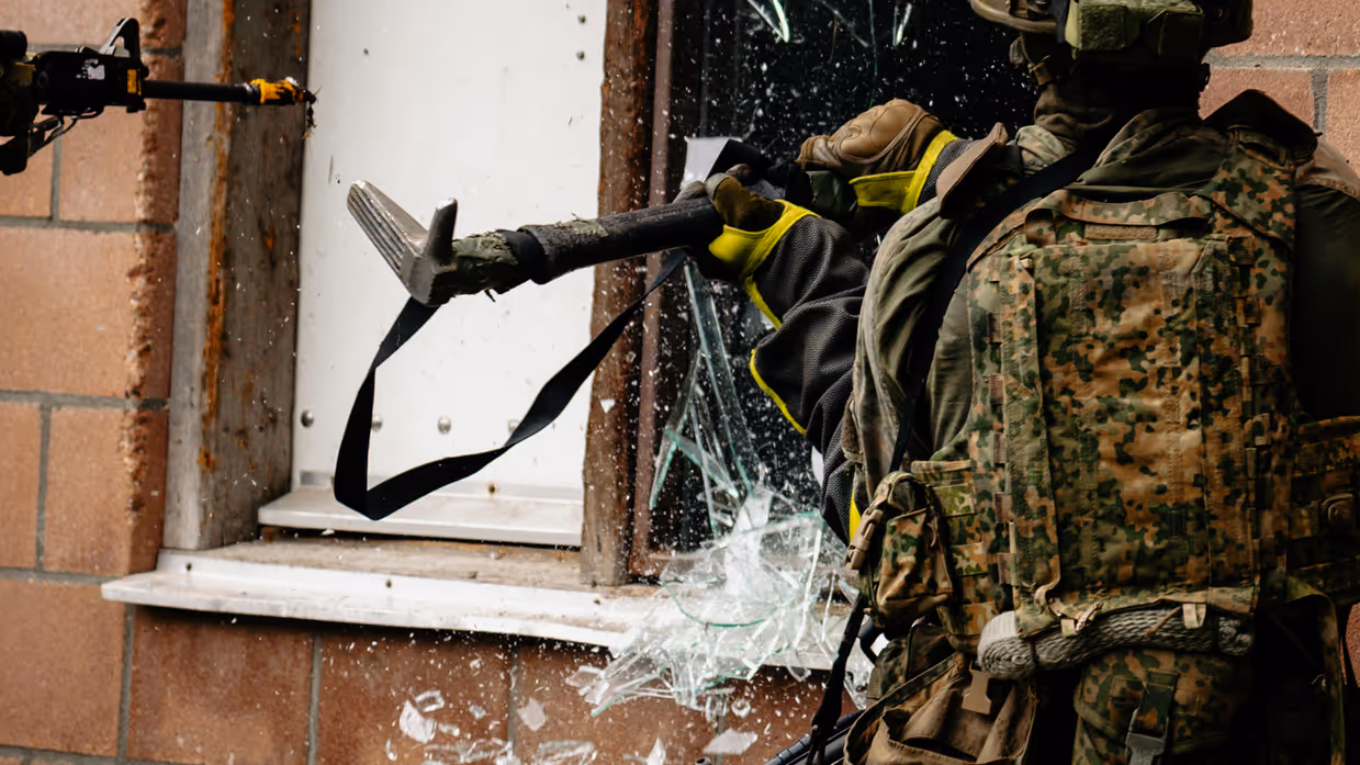 Militairen slaan een raam in.