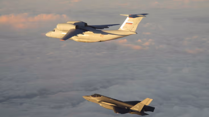 Een Nederlands toestel dat een Russisch vliegtuig in de lucht begeleidt.