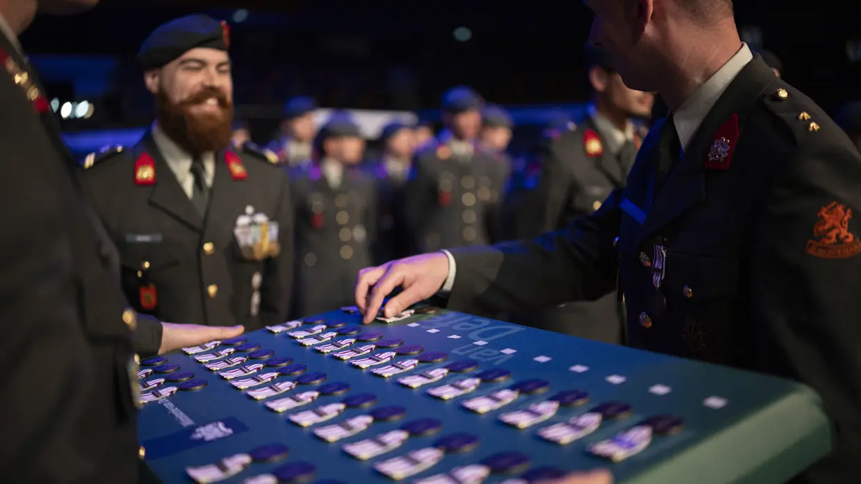 Militair staat klaar om medaille in ontvangst te nemen. 
